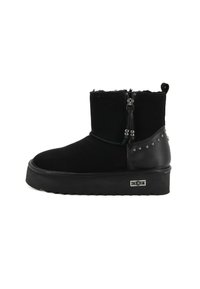 Czarny botek za kostkę z grubą podeszwą, zamkiem błyskawicznym z boku, metalowymi ćwiekami na obcasie oraz markowym logo metalowym na krawędzi podeszwy.