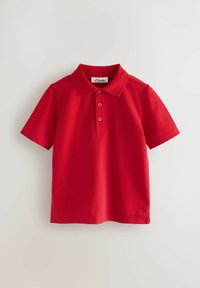 Polo rojo de manga corta hecho de algodón. Presenta un cuello clásico, tres botones y un logo bordado en la parte inferior izquierda.