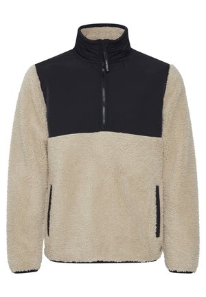 Fleece pullover with high collar, beige body, black upper panel, and side pockets. Textured surface with a soft, warm appearance.