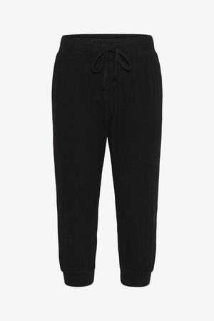 Pantalons de jogging noirs en tissu doux, avec une taille élastique à cordon de serrage et des poignets élastiques aux chevilles.