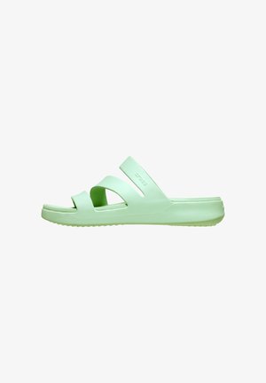 Lys grøn slip-on sandal med to brede stropper og en bagrem, designet til hverdag, set fra siden.
