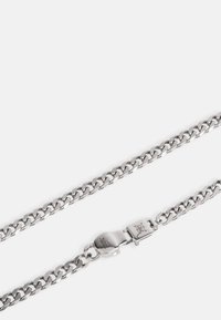 Zilveren ketting met dikke, in elkaar grijpende schakels met een gladde afwerking. Voorzien van een veilige sluiting met gegraveerd logo detail.