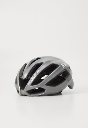 Harmaa pyöräilykypärä, jossa on useita ilmanvaihtoaukkoja, sulavalinjainen muotoilu ja kiiltävä pinta. Sivussa on brändäys ja kompakti muoto.