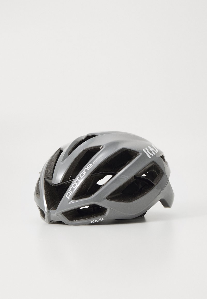 Casque de vélo gris avec plusieurs aérations, au design épuré et à la finition brillante. Présente un logo sur le côté et une forme compacte.