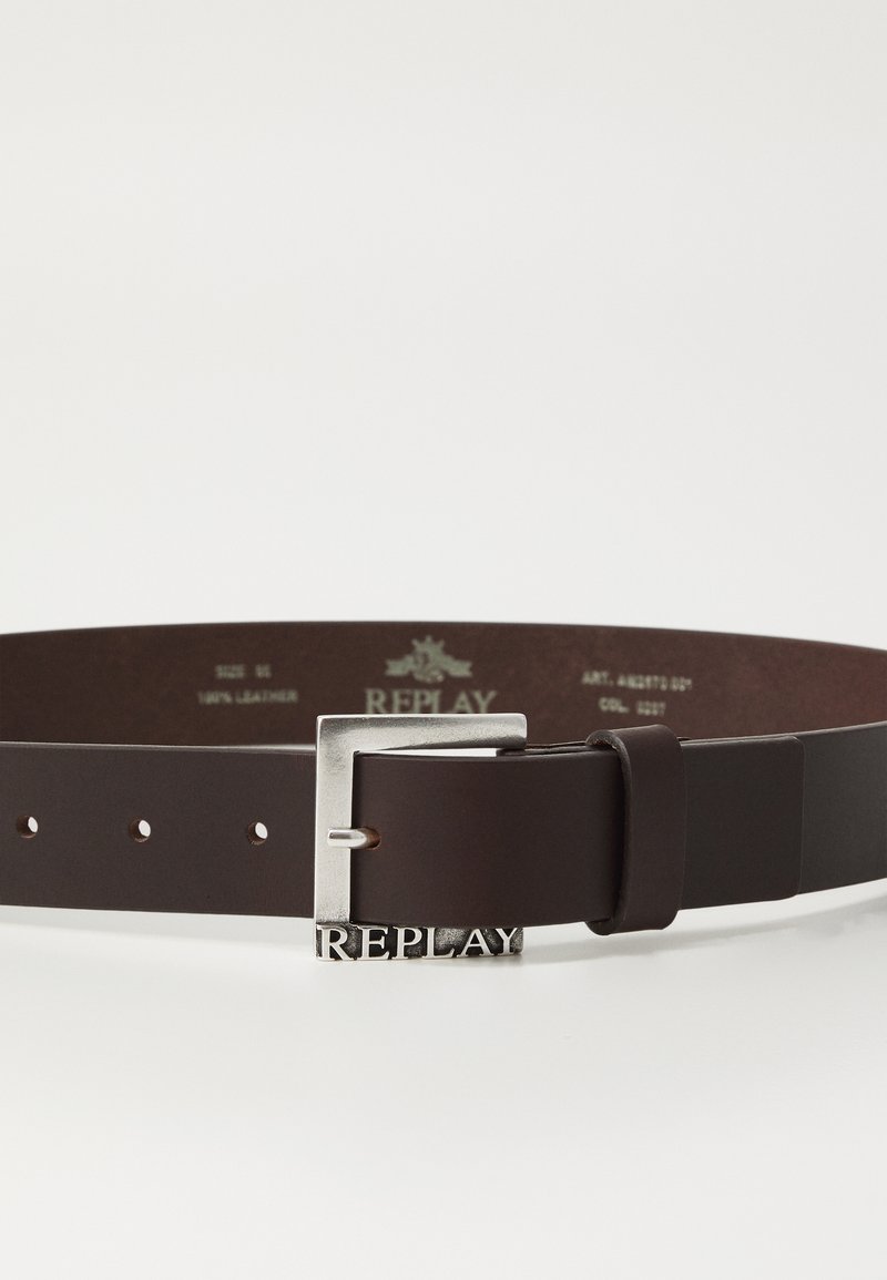 Cintura in pelle marrone con una fibbia in metallo argento che presenta il logo "REPLAY". Texture liscia, multiple fori regolabili, design minimale.