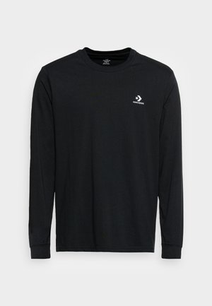 Sort langærmet crewneck-shirt med hvid Converse-stjerne og chevron-logo på venstre bryst, vist på hvid baggrund.