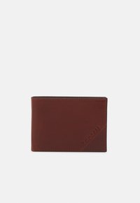 Portefeuille en cuir marron avec une finition lisse, présentant un accent texturé dans un coin et un nom de marque en relief. Forme rectangulaire compacte.