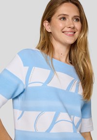 Blue and white striped top with a relaxed fit, featuring textured fabric and decorative stitch patterns along the stripes.