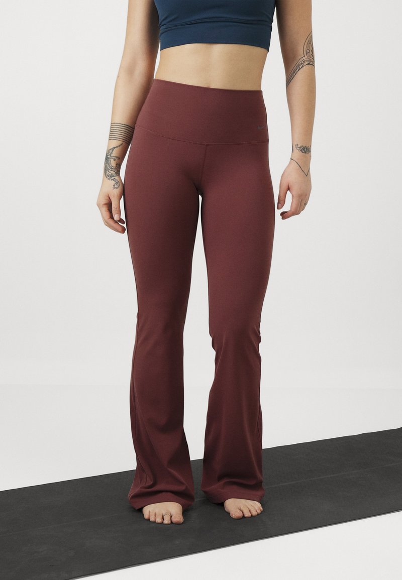 Bordeaux flared yogabroek gemaakt van rekbare stof, met een hoge tailleband en een zachte textuur, gecombineerd met een donkerblauwe crop top.