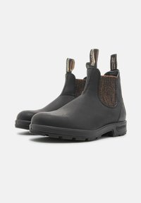 Bottines Chelsea en cuir noir avec des panneaux élastiqués sur les côtés, des accents marron texturés, des languettes de tirage et des semelles en caoutchouc pour une meilleure adhérence.