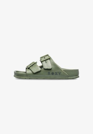 Green double-buckle slide sandal with textured synthetic straps and a padded footbed. Features branding on the side. Flat rubber sole.
