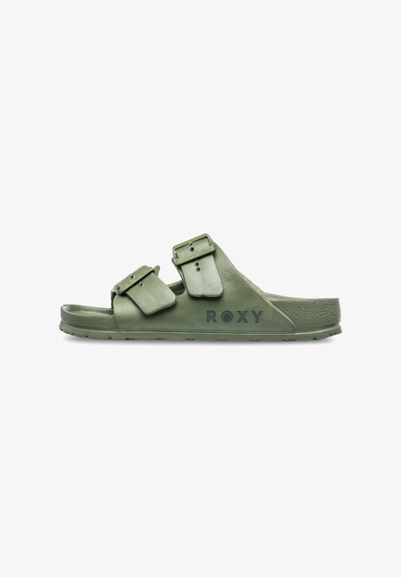Green double-buckle slide sandal with textured synthetic straps and a padded footbed. Features branding on the side. Flat rubber sole.