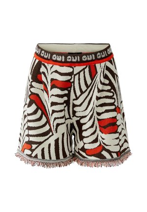 Gebreide korte broek met abstract bruin, wit en rood zebra-achtig dessin, franjes aan de zoom en een elastische tailleband met herhaalde tekst “oui”.