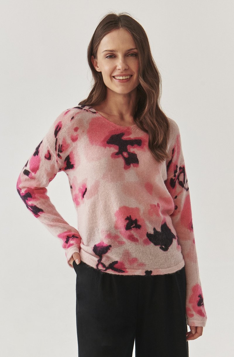 Helles rosa Sweatshirt mit abstraktem Blumenmuster in Rosatönen und Schwarz. Weiche, gestrickte Textur, lange Ärmel und runder Ausschnitt.
