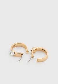 Σκουλαρίκια κρίκοι από χρυσό με λείο φινίρισμα, διακοσμημένα με ένα διαφανές πολύτιμο λίθο στη μία πλευρά και απλή κλεισίμα με γάντζο.