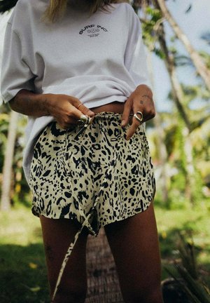 Szorty w beżowo-czarny wzór w panterkę, wykonane z lekkiego materiału, z elastycznym pasem i sznurkiem do regulacji.