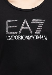 Μαύρο βαμβακερό μπλουζάκι με μεγάλα γράμματα από στρογγυλά στρας "EA7 EMPORIO ARMANI" σε έντονο σχέδιο, με λεία υφή και στρογγυλή λαιμόκοψη.