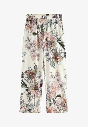 Spodnie w kwiatowy wzór z miękkiego materiału, z dużymi różowymi i zielonymi kwiatami na kremowym tle, z elastycznym pasem i szerokimi nogawkami.