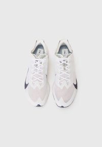 White athletic shoes with textured mesh upper, lacing system, and dark gray accents. Lightweight design with a rounded toe and flat sole.