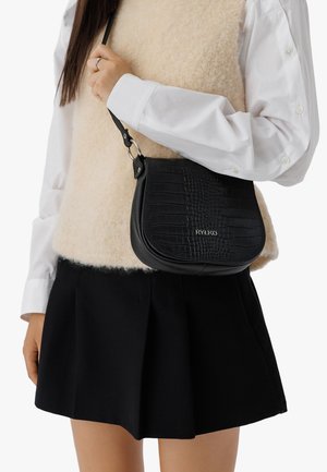 Bolso cruzado negro con patrón de cocodrilo, material de cuero, forma redondeada, con detalles en plata y una correa ajustable.