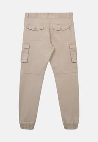 Beżowe spodnie cargo z elastycznymi mankietami, dwoma zasuwanymi kieszeniami z tyłu oraz dwiema kieszeniami z przodu, wyeksponowane na płasko z tyłu.