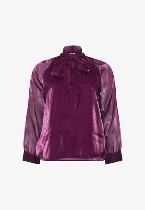 Blusa de seda en púrpura profundo con cuello alto y detalle de lazo. Presenta mangas largas y transparentes y un cuerpo sólido, ligeramente brillante.
