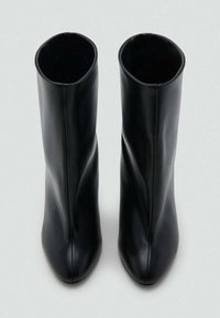 Črni škornji do kolen iz gladkega usnja, s prefinjeno silhueto, ostrim noskom in čistim šivom ob všitkih.