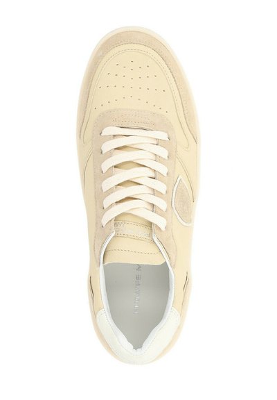 Sneaker in suede e pelle beige con punta perforata, lacci crema e suola bianca a contrasto. Presenta un logo sottile di lato.