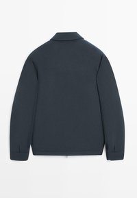 Mørk marineblå jakke med lange ærmer, krave, lige kant og manchetter med knapper, vist bagfra på en hvid baggrund.