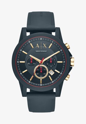 Orologio con cinturino in silicone nero, quadrante rotondo nero, dettagli dorati, indicatori rossi, tre sottodial e una finestra per la data alle 6.