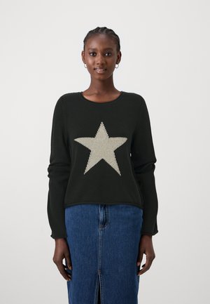 Zwarte trui met lange mouwen en een grote zilveren gebreide ster aan de voorkant. Gecombineerd met een denim rok, die een splitdetail laat zien.