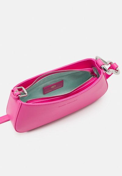 Borsa in pelle rosa con hardware in argento, forma rotonda e chiusura con zip. L'interno presenta una fodera teal e un'etichetta con il marchio.