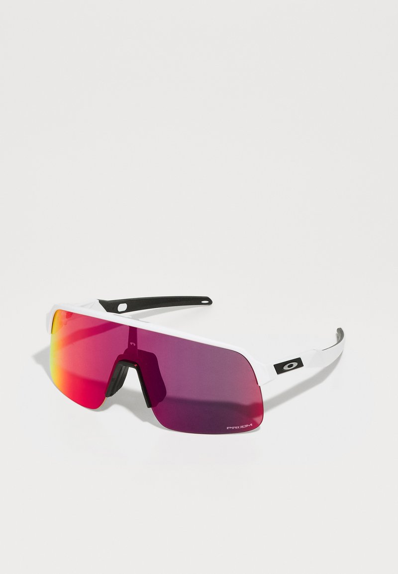 Gafas de sol deportivas con un marco blanco, grandes lentes curvados de degradado púrpura y detalles en negro. Pieza de nariz de goma texturizada para un mejor agarre.