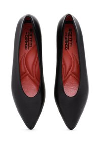 Ballerine in pelle nera con punta affusolata e dettagli ritagliati. L'interno presenta una fodera rossa testurizzata con motivi a onda.