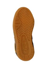 Semelle de chaussure en caoutchouc présentant un motif en zigzag, avec une base marron et des accents latéraux noirs. Logo "Gola" embossé sur la semelle intermédiaire.