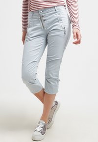 Ljust blå cropped byxor med en slät midja, dragkedja och knäppning, sidodragkedjor och uppvikta fållar, tillverkade av ett mjukt, elastiskt tyg.