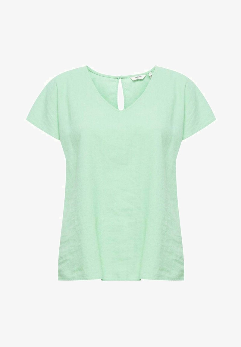 Blouse vert clair à manches courtes avec encolure en V et petite fermeture bouton œillet au niveau du col arrière.