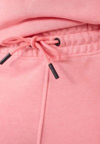 Roze sweatpants met een trekkoord in de taille, voorzien van zwarte aglets en een zachte, gestructureerde stof. Elastische boorden bij de enkels.