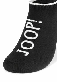 Calzini neri alla caviglia con testo a maglia bianco "JOOP!" sul lato e un bordo bianco a contrasto. Texture morbida con una finitura liscia.