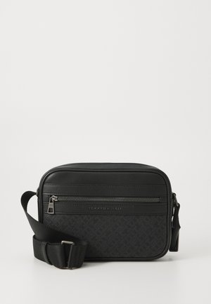Sac bandoulière noir Tommy Hilfiger avec poche avant zippée, sangle d'épaule réglable et motif texturé subtil sur le panneau en tissu.