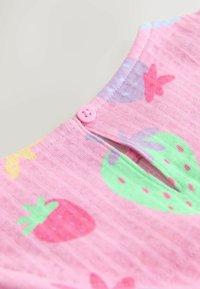 Camiseta rosa para niños con un estampado de fresas en varios colores. Tiene un pequeño botón rosa y un escote redondo con un diseño partido.