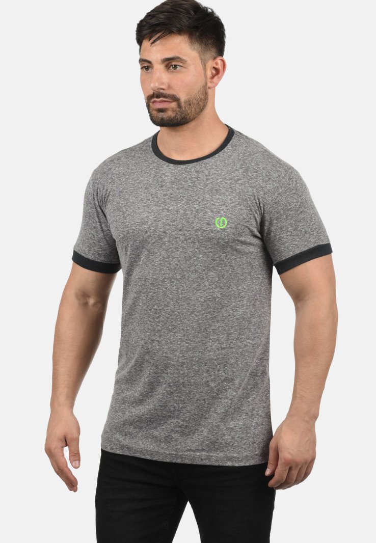 Camiseta gris de manga corta con cuello y puños de manga negros. Presenta un pequeño logo verde en la parte izquierda del pecho. Textura de tela suave.