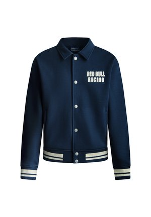 Mørkeblå varsity-jakke med knappelukking foran, hvit tekst "RED BULL RACING" og stripete ribbkanter og hem. Glatt tekstur på stoffet.