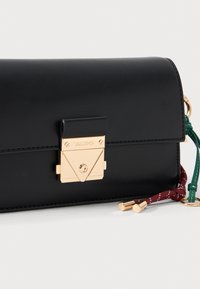 Clutch in pelle nera con hardware dorato, dotata di una chiusura triangolare, dettagli in verde e bordeaux, e una superficie liscia.