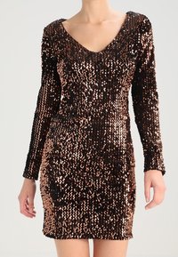 Kort, figursydd klänning med långa ärmar, tillverkad av glittrande paljetter i en gradient från svart till rosaguld, med en djup V-ringning.