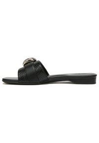 Black slide sandal with two textured straps, one featuring a circular silver accent. Smooth sole, minimal heel, and sleek design.