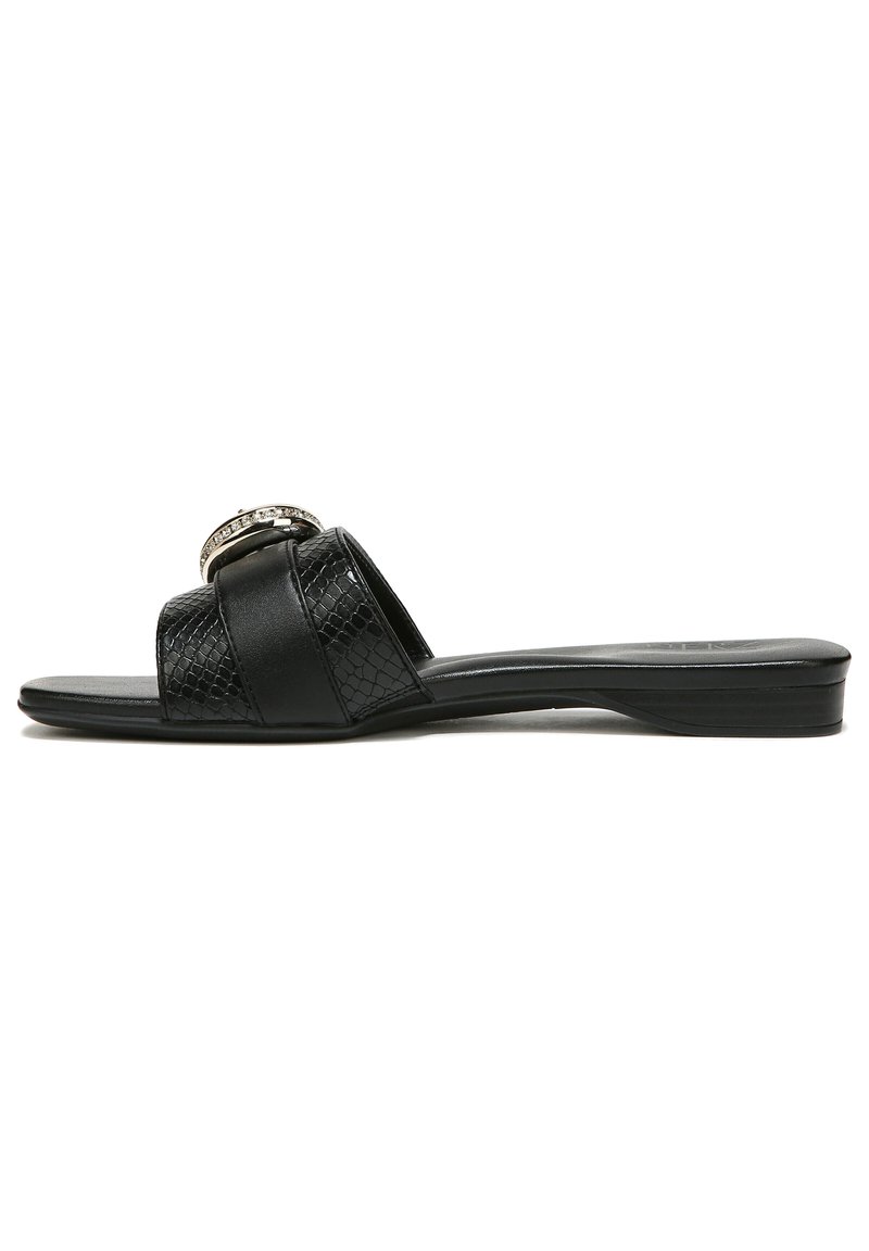 Black slide sandal with two textured straps, one featuring a circular silver accent. Smooth sole, minimal heel, and sleek design.
