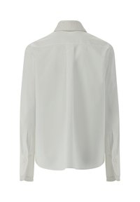 Camicia bianca a maniche lunghe con colletto strutturato e decorato. Design semplice con bottoni ai polsini, tessuto liscio e schiena dritta.