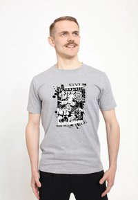 Šedé bavlněné tričko s černým potiskem ve stylu graffiti, na přední straně je text a detaily rozstřiku umístěné ve středu. Pohodlný střih, krátké rukávy.