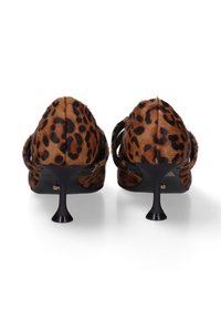 Chaussures à talons hauts imprimées léopard, avec une texture duveteuse, un talon aiguille noir, un design ouvert à l'arrière, et une fine sangle autour de la cheville.